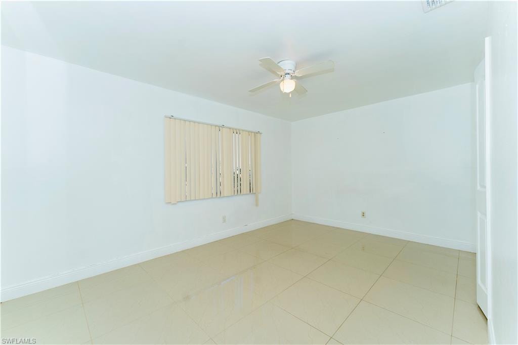 Unfurnished room with baseboards and a ceiling fan