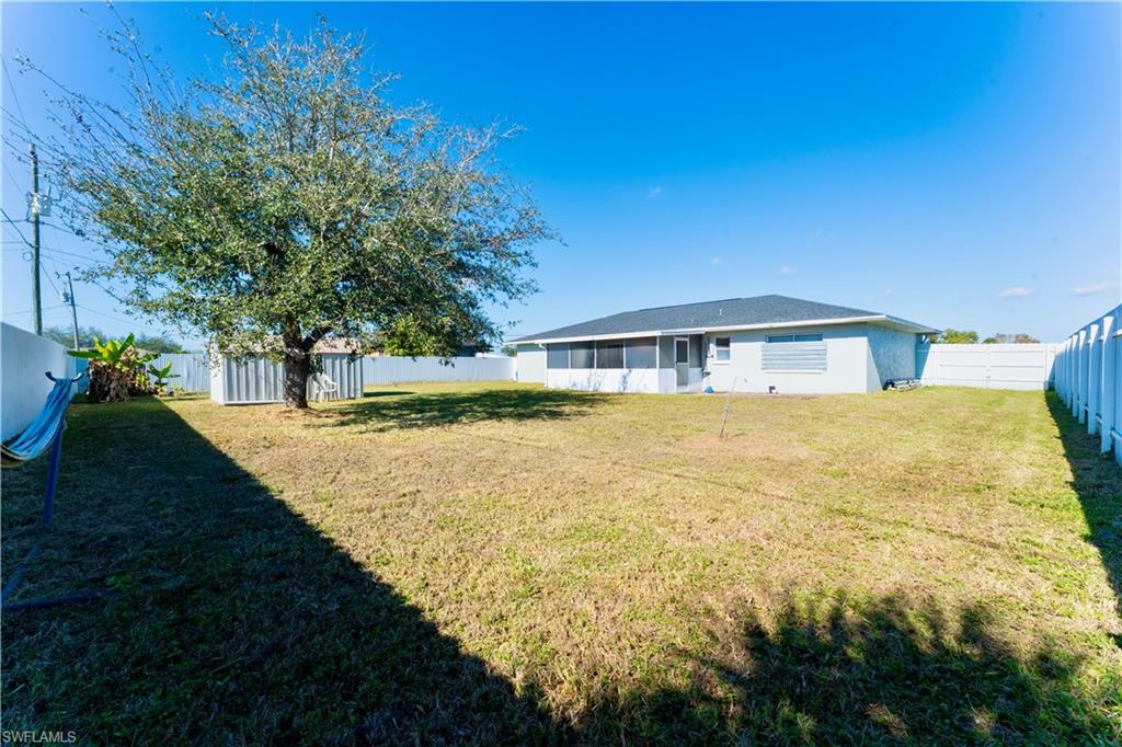 Back of property with a fenced backyard and a shed