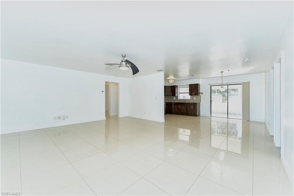 Empty room featuring a ceiling fan and light tile patterned floors