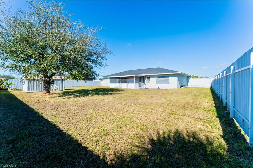 Rear view of property featuring a fenced backyard and an outdoor structure