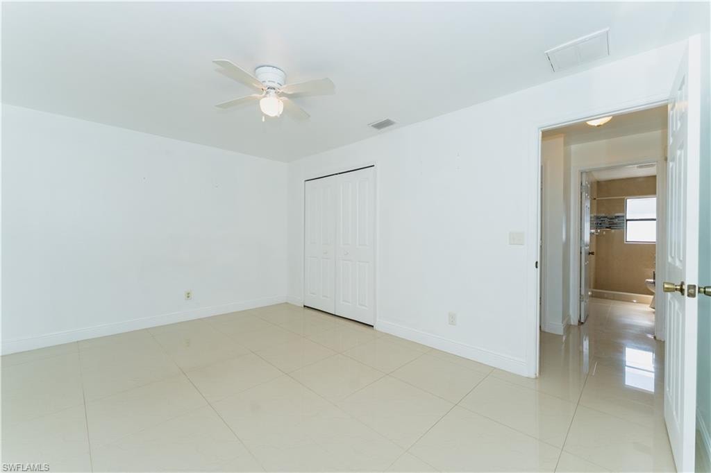 Unfurnished bedroom featuring a closet, a ceiling fan, and light tile patterned floors