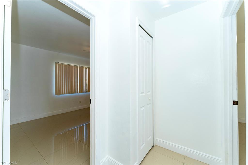 Corridor with light tile patterned floors and baseboards