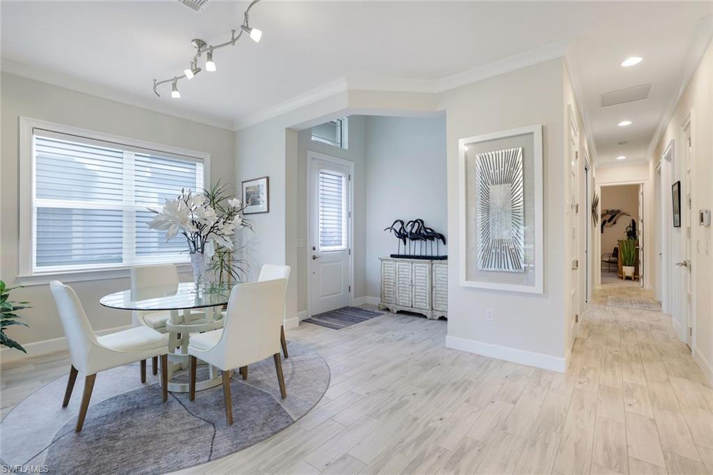 Dining area with light hardwood / wood-style floors, plenty of natural light, and ornamental molding