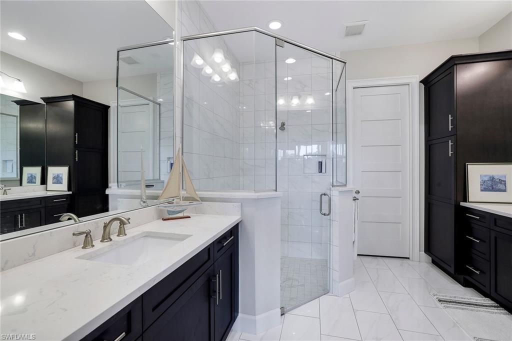 Bathroom featuring vanity and a shower with door
