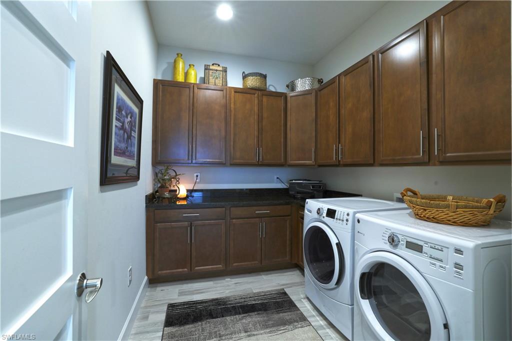 Washroom featuring light hardwood / wood-style floors, cabinets, and separate washer and dryer