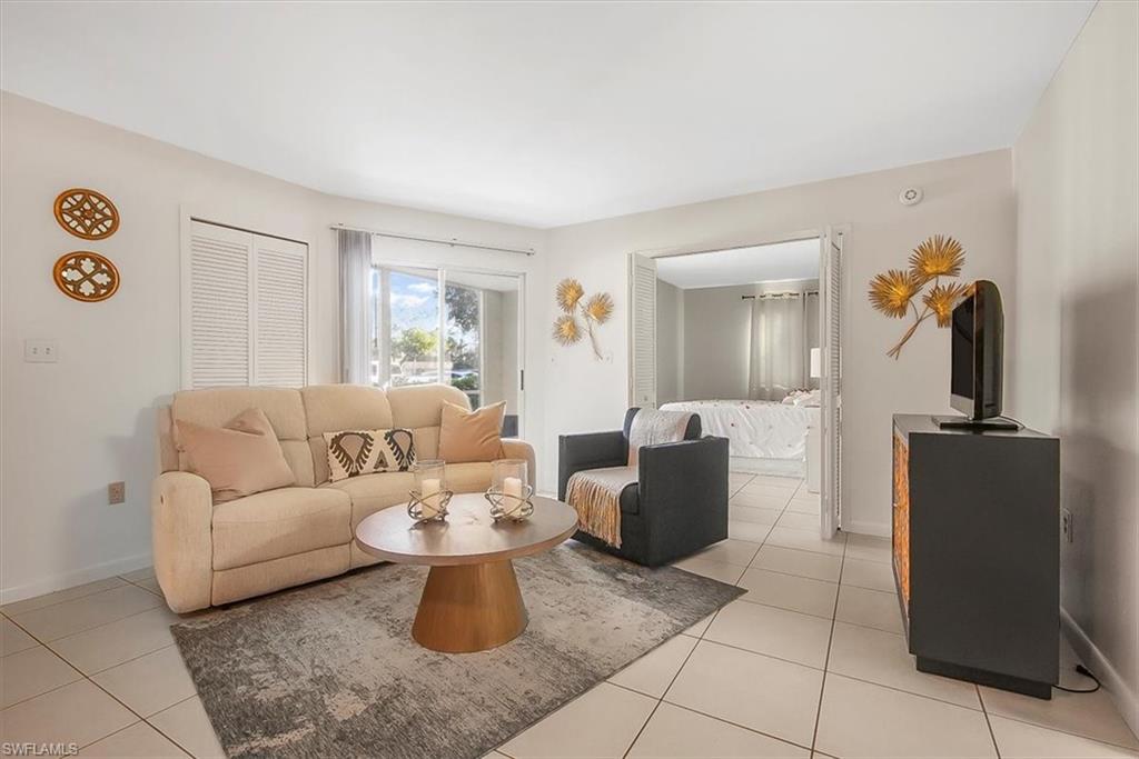 Living room with light tile patterned flooring and baseboards