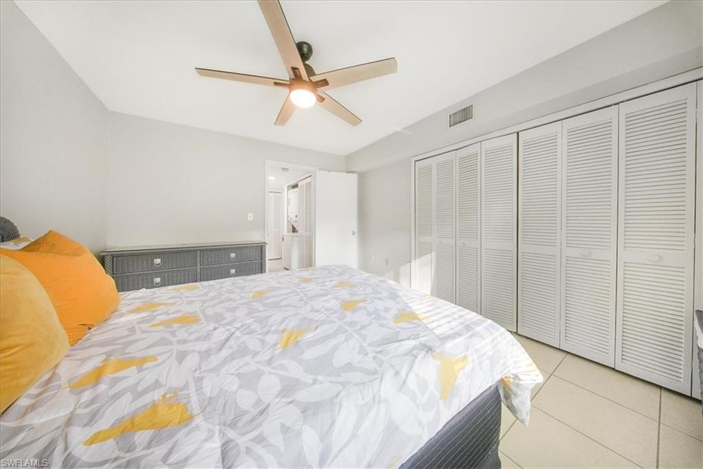 Bedroom featuring light tile patterned floors, ceiling fan, and a closet