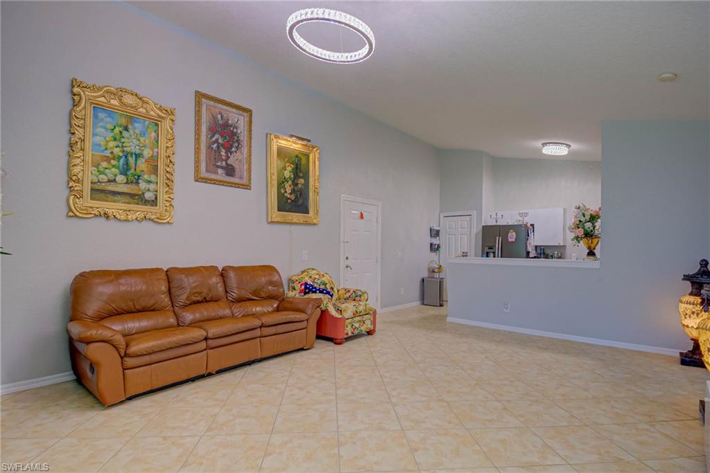 Living area with vaulted ceiling and light tile patterned flooring