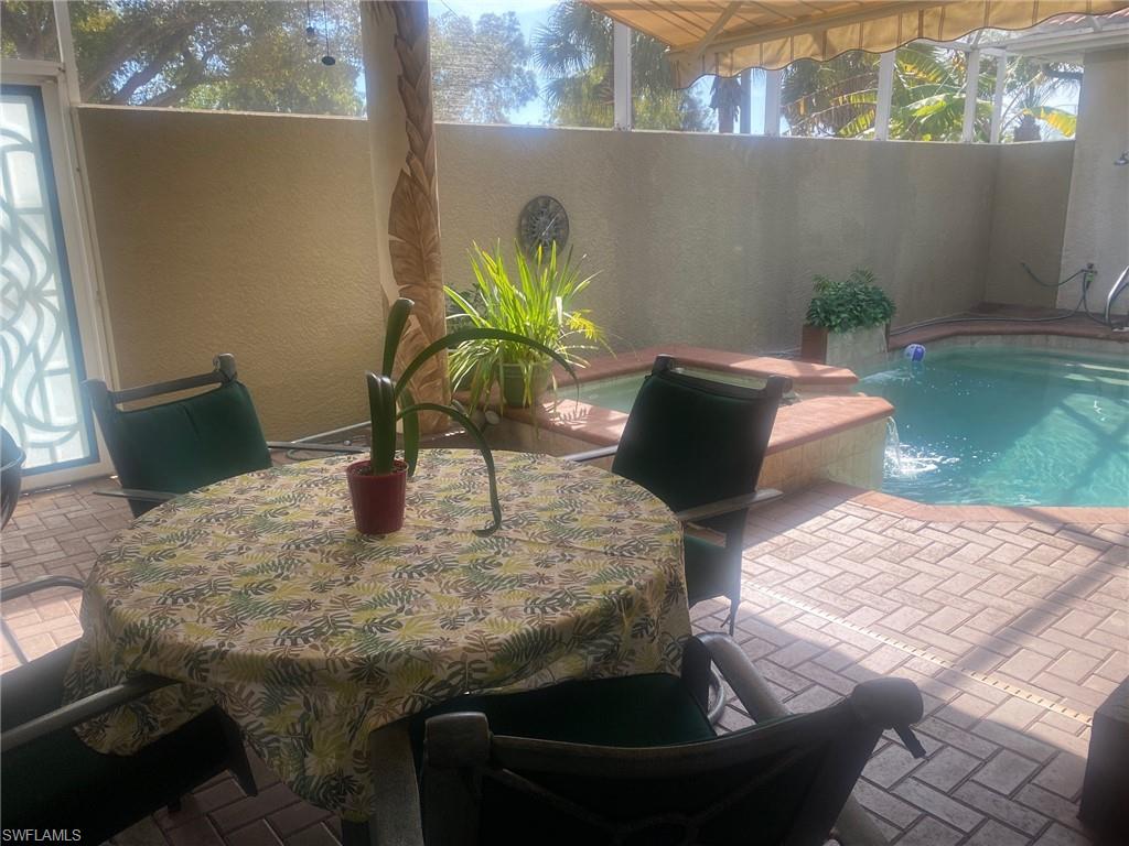 Under cover seating area with retractable awning looking over pool courtyard