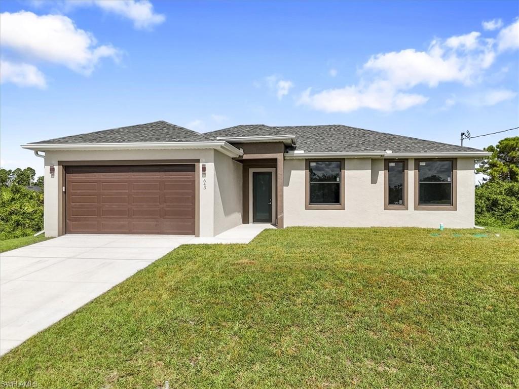 View of front of home featuring stucco siding, roof with shingles, and a garage