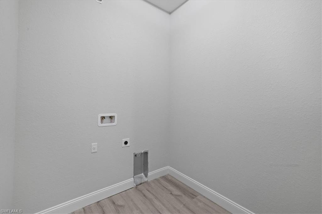 Laundry area featuring light wood-style floors, hookup for an electric dryer, and washer hookup