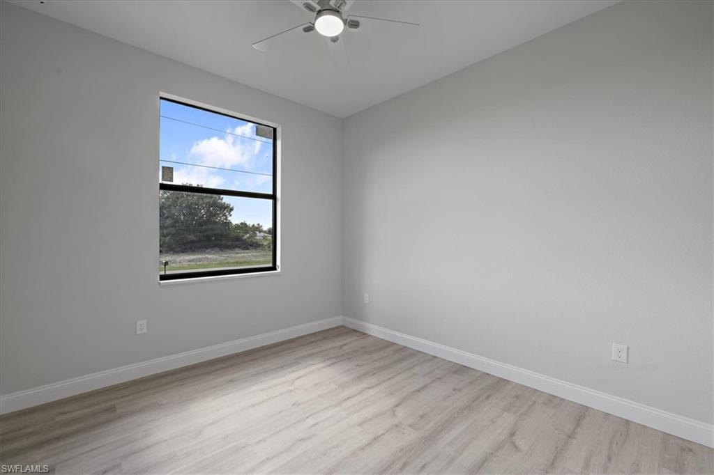 Unfurnished room with light wood finished floors and a ceiling fan