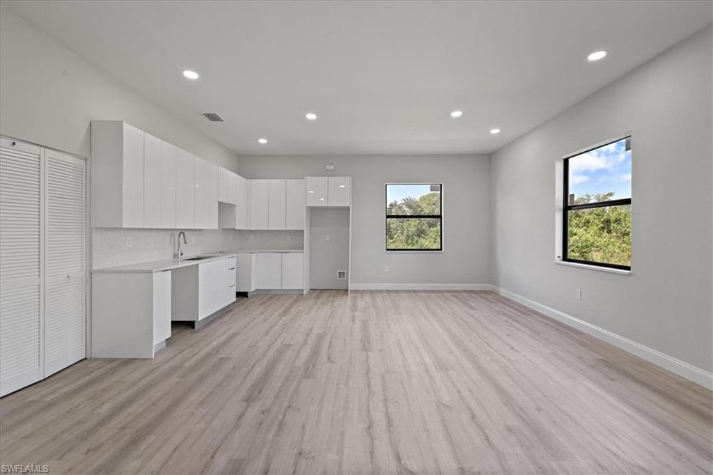 Unfurnished living room featuring light wood finished floors, recessed lighting, and plenty of natural light