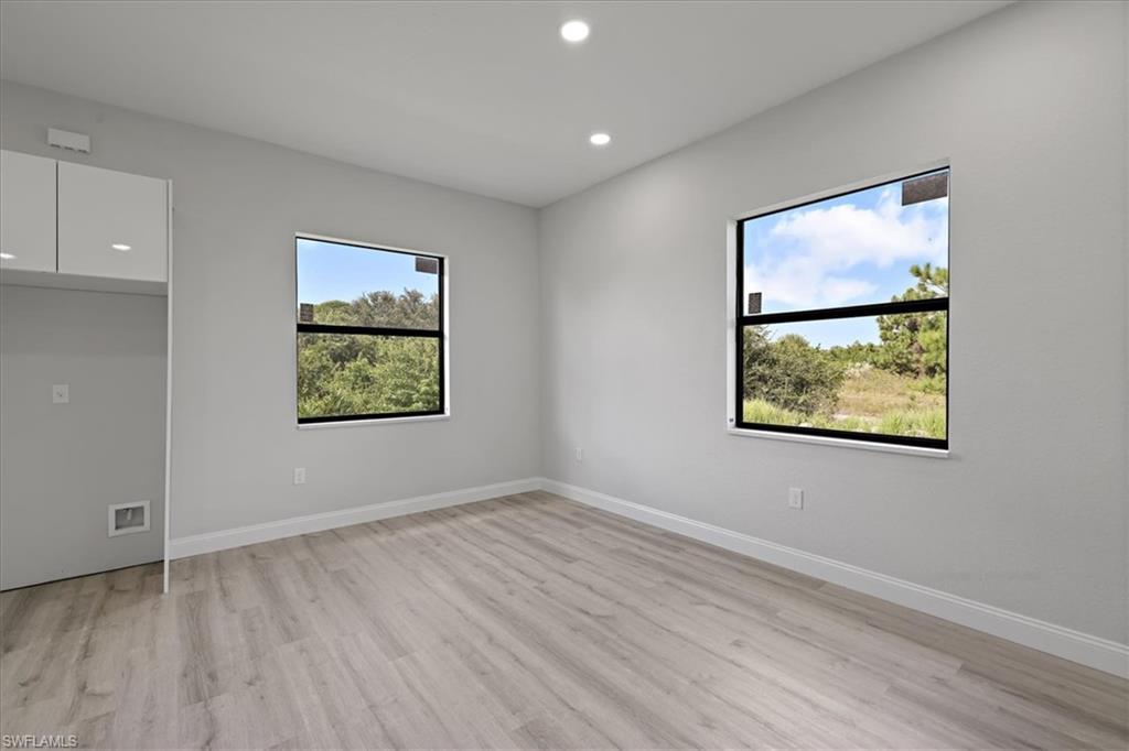Spare room with recessed lighting, healthy amount of natural light, and light wood-type flooring