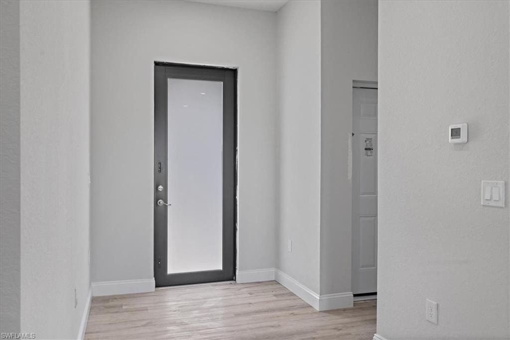 Foyer featuring light wood-type flooring and baseboards