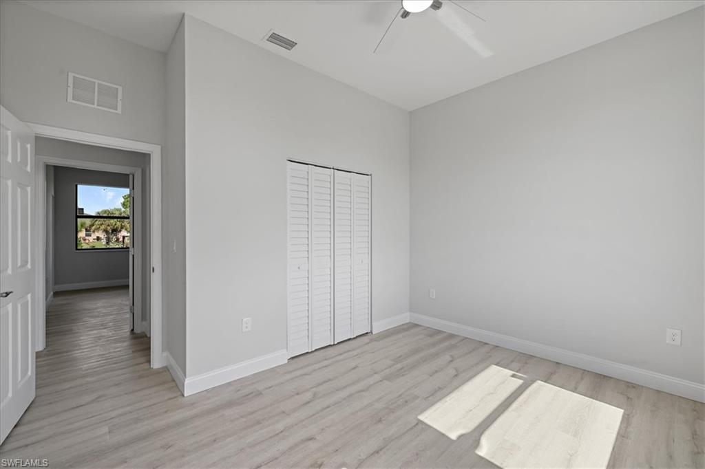 Unfurnished bedroom featuring light wood finished floors, ceiling fan, and a closet