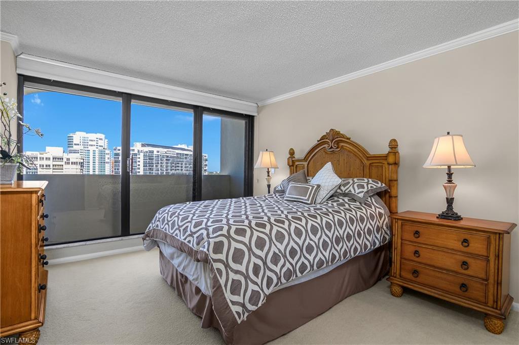 Second Bedroom with ornamental molding, light colored carpet, a textured ceiling, and a view of city and Gulf