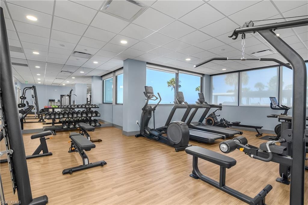Workout area featuring a paneled ceiling and recessed lighting, outdoor views