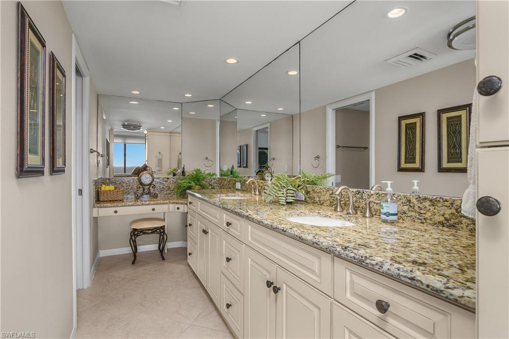 Master bathroom with double vanity, recessed lighting, light tile patterned floors, and backsplash