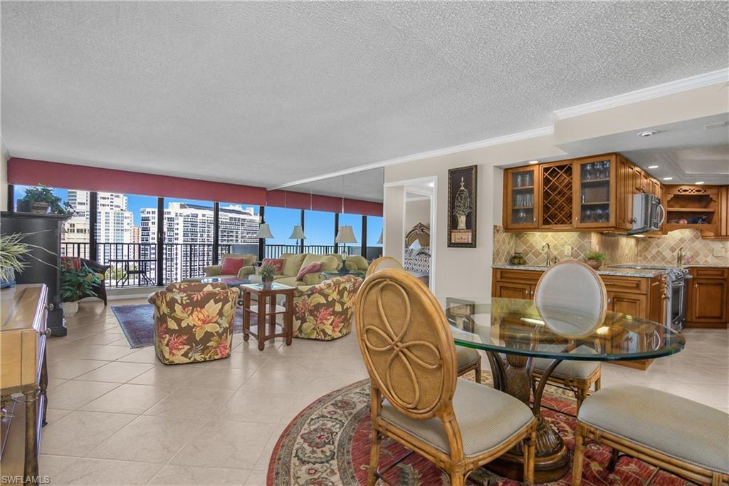 Dining room featuring ornamental molding, a textured ceiling, light tile patterned floors, and a city view