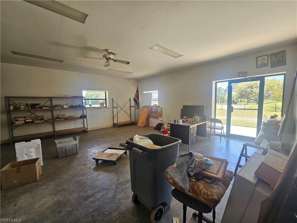 Living area featuring ceiling fan and concrete floors