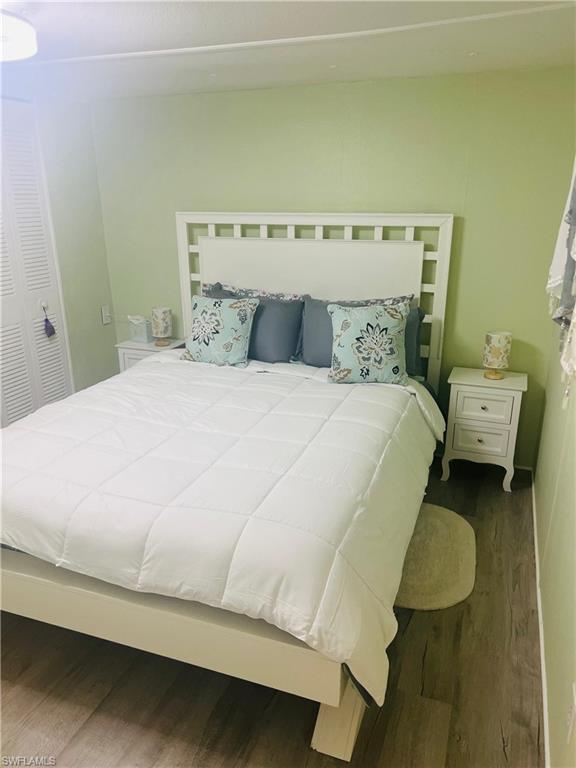 Bedroom with wood finished floors and a closet