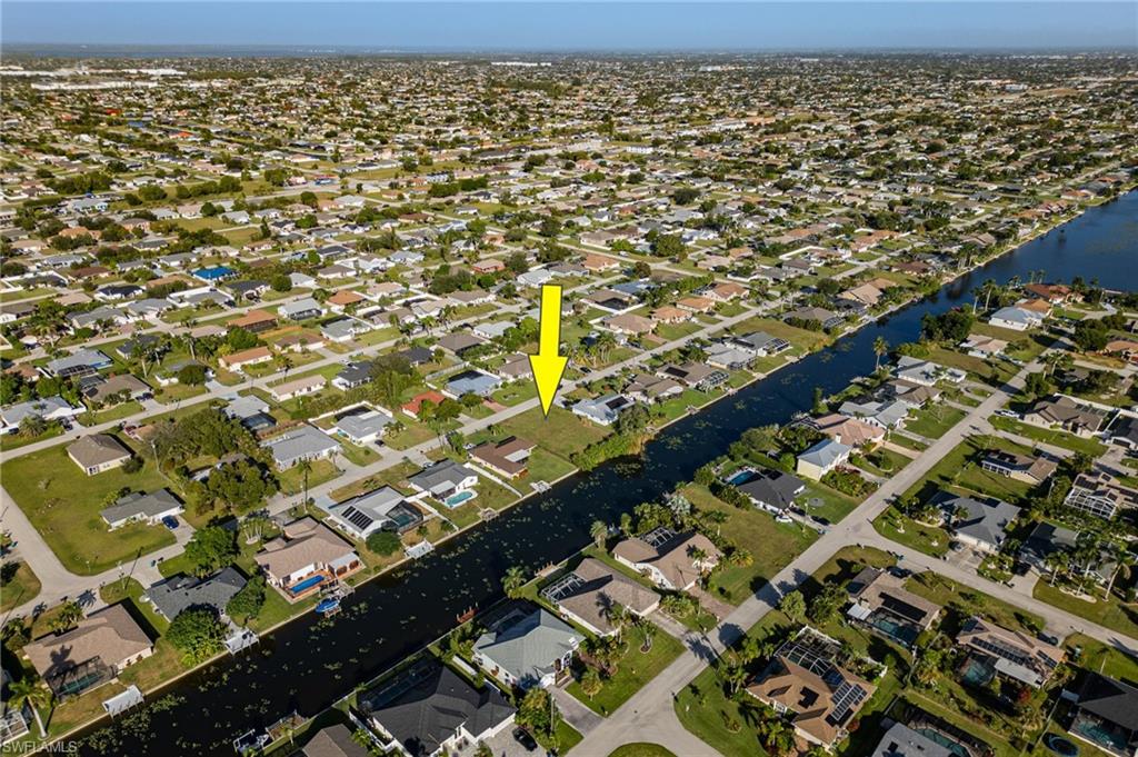 Aerial view of property and surrounding area featuring nearby suburban area.
