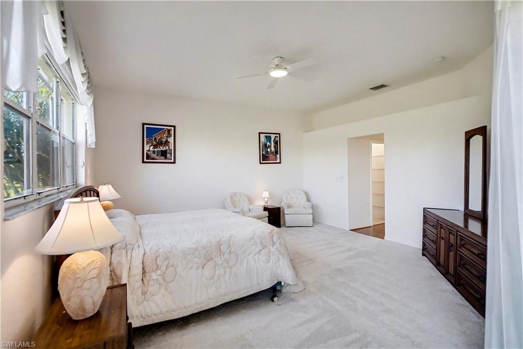 Carpeted bedroom featuring a ceiling fan