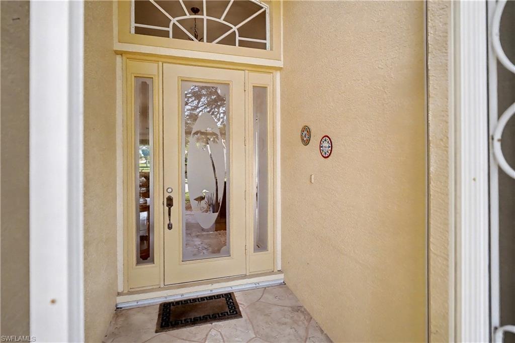 Doorway to property featuring stucco siding