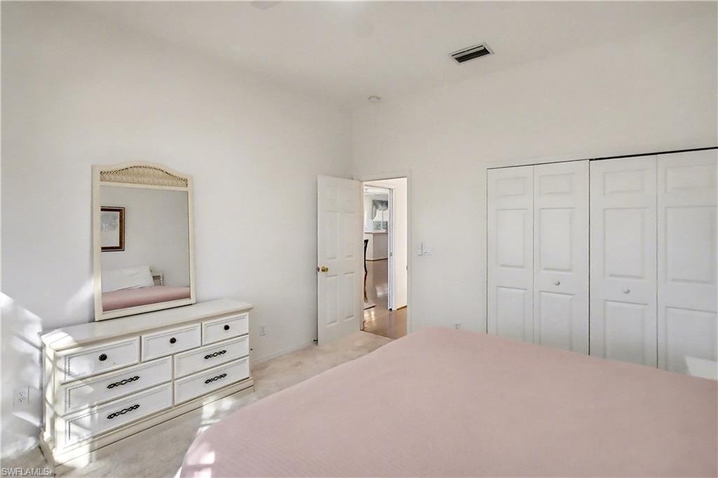 Bedroom featuring light carpet and a closet