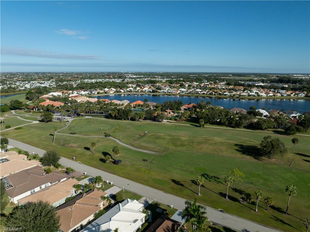 Aerial view of residential area with a golf club and a nearby body of water