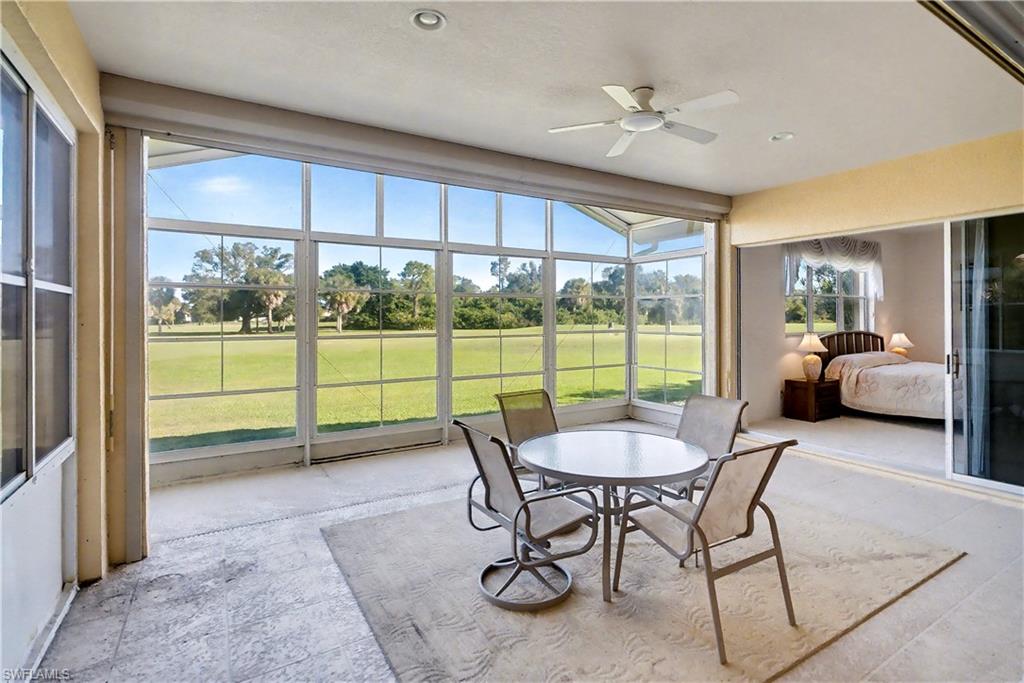 Sunroom with ceiling fan and view of golf course