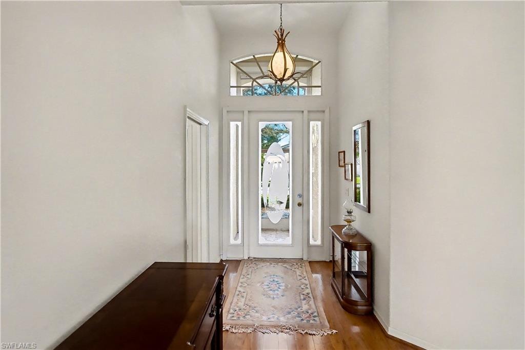 Entrance foyer with wood finished floors and a high ceiling
