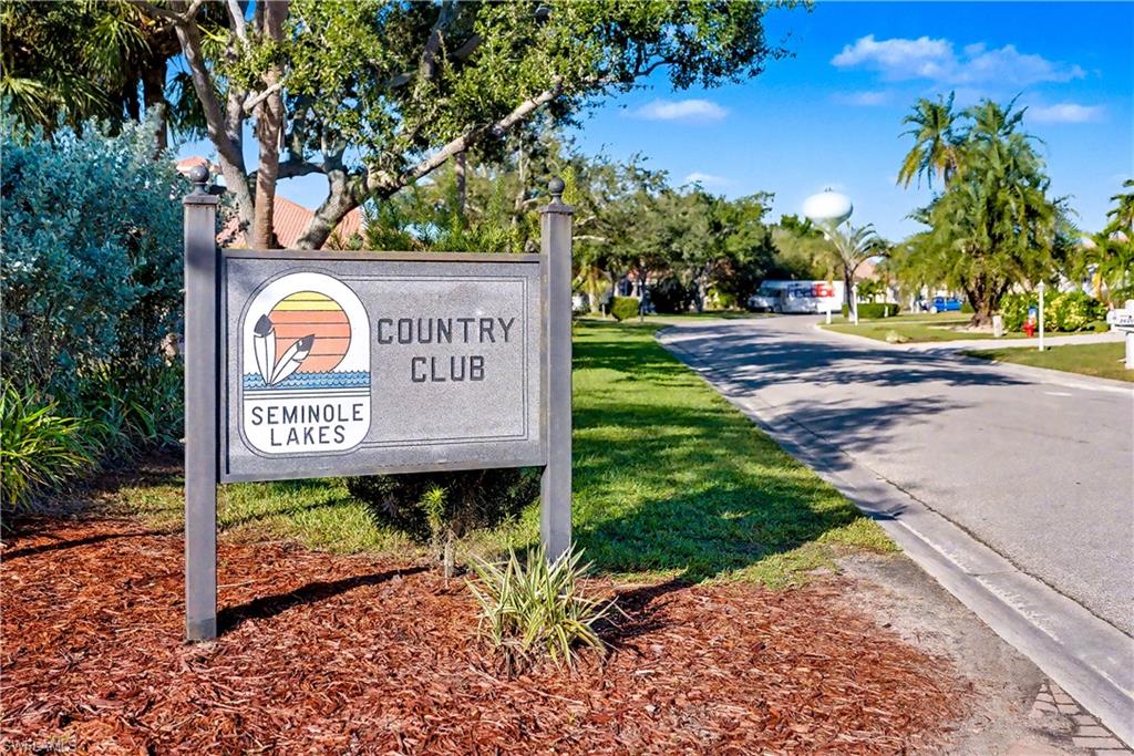 Community / neighborhood sign featuring a yard