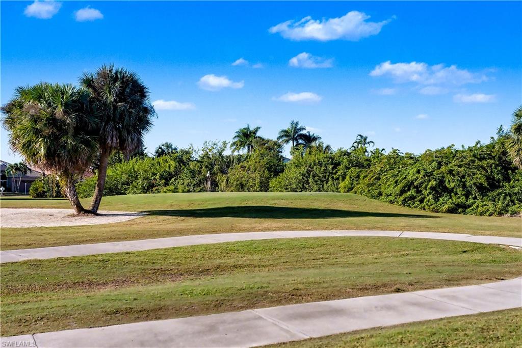 Surrounding community with a lawn and view of golf course
