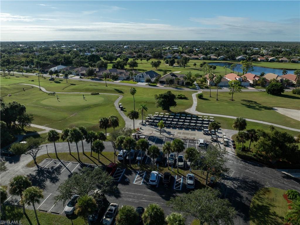 Aerial perspective of suburban area featuring a large body of water and a golf course