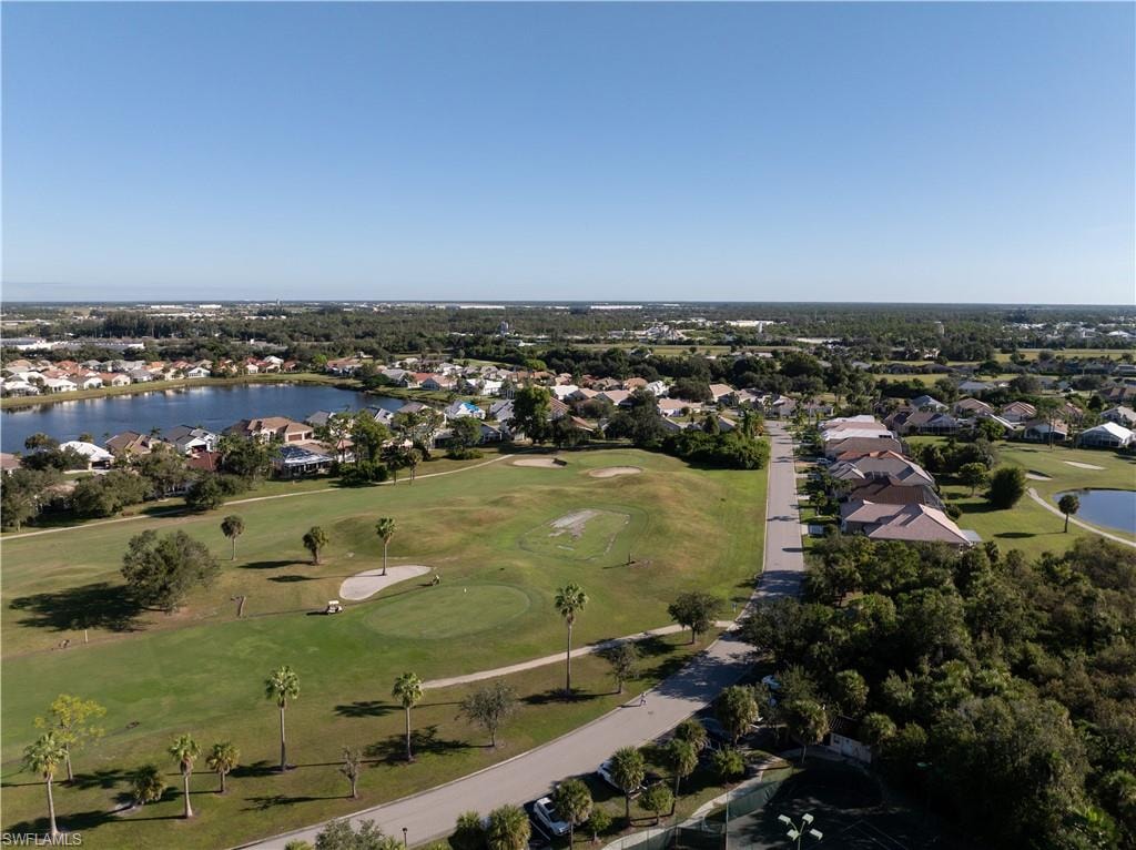 Aerial view of property's location featuring a nearby body of water, nearby suburban area, and a golf club