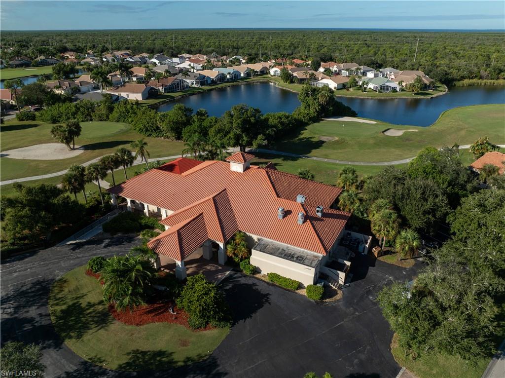 Aerial view of residential area featuring a nearby body of water and a golf club