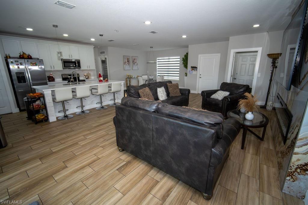 Living room with light wood-style flooring and recessed lighting