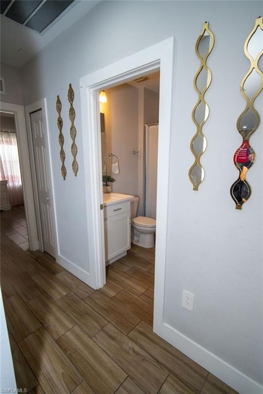 Corridor featuring wood tiled floors and baseboards