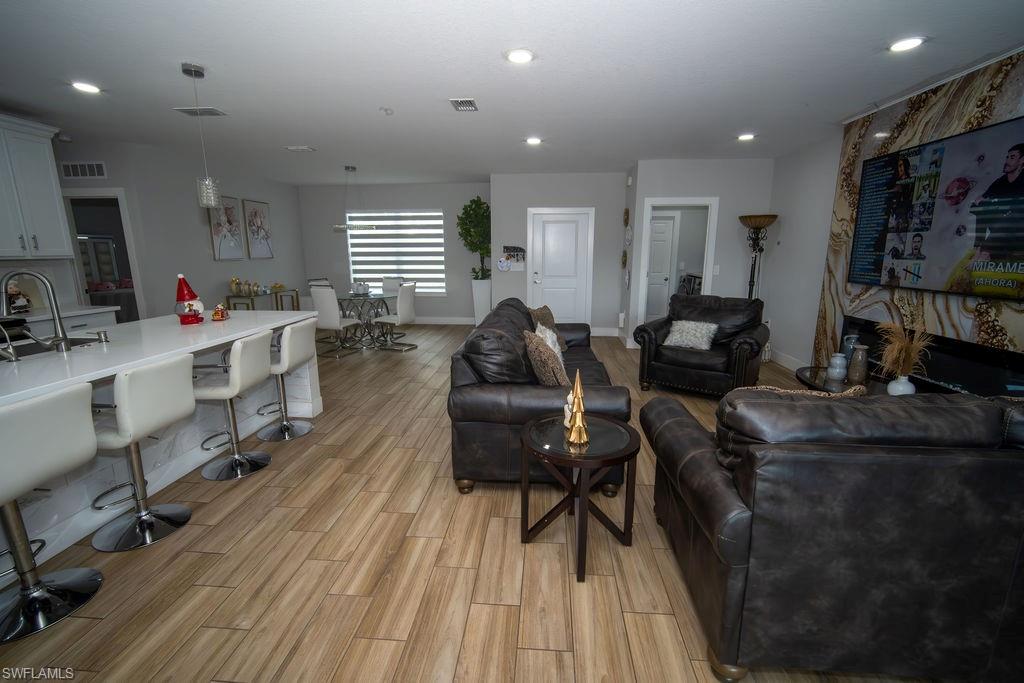 Living room with light wood-style flooring and recessed lighting