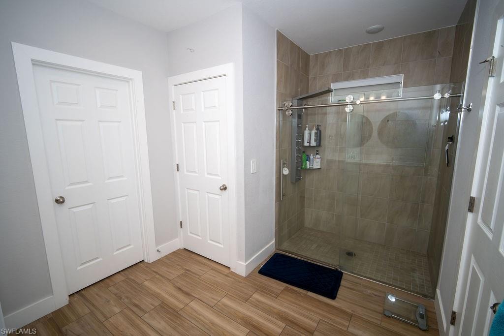 Full bath with a stall shower and wood finished floors