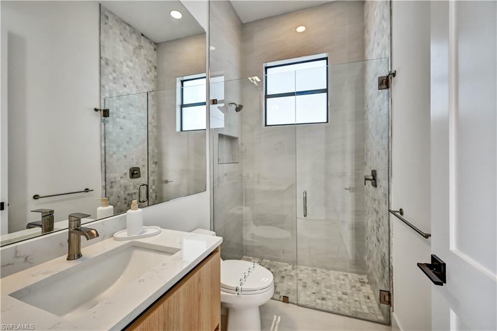 Full bathroom featuring vanity, a shower stall, and recessed lighting