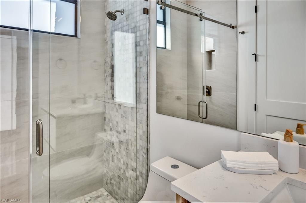 Full bath featuring a shower stall and vanity