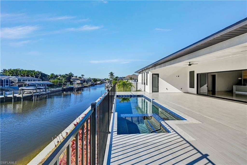 View of swimming pool featuring an infinity pool, a water view, and patio surround