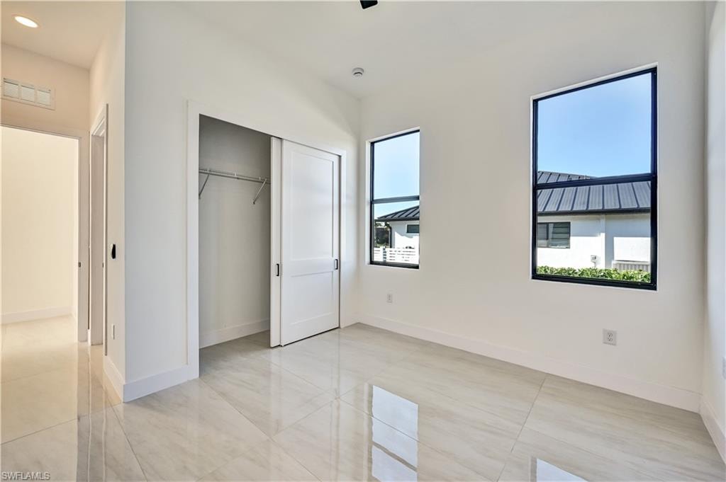 Unfurnished bedroom featuring a closet and light tile patterned floors