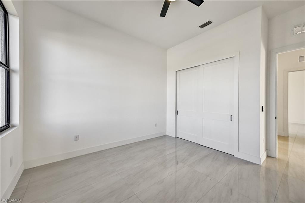 Unfurnished bedroom featuring ceiling fan and a closet