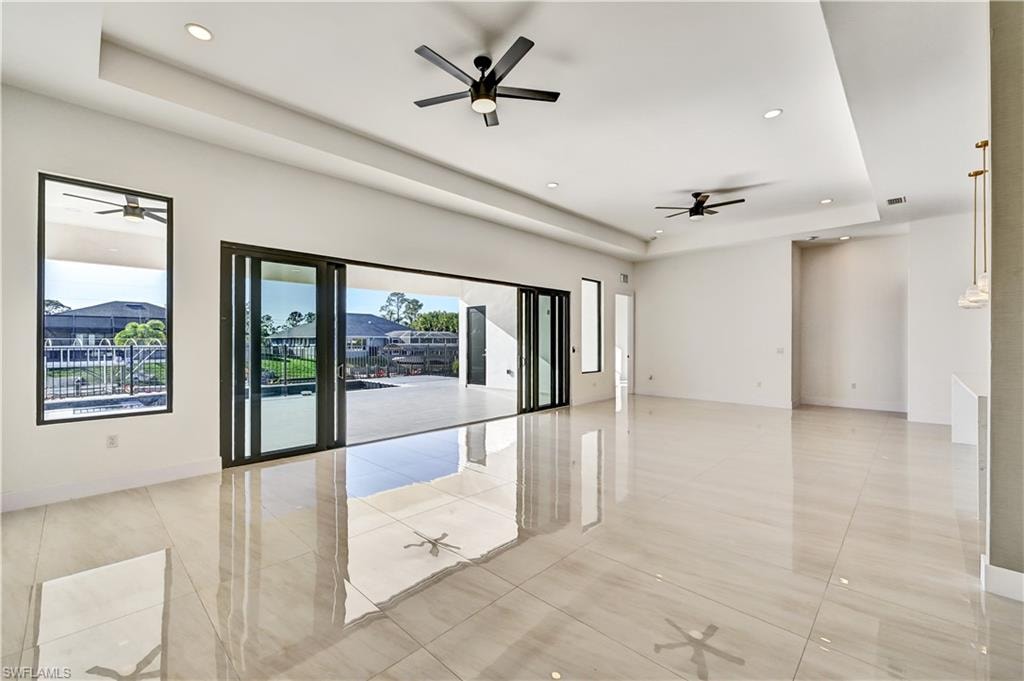 Unfurnished room featuring a ceiling fan, a tray ceiling, and recessed lighting