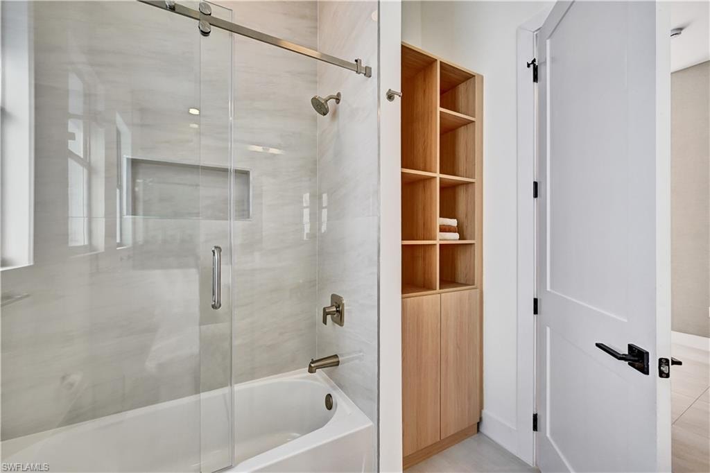 Full bath with combined bath / shower with glass door