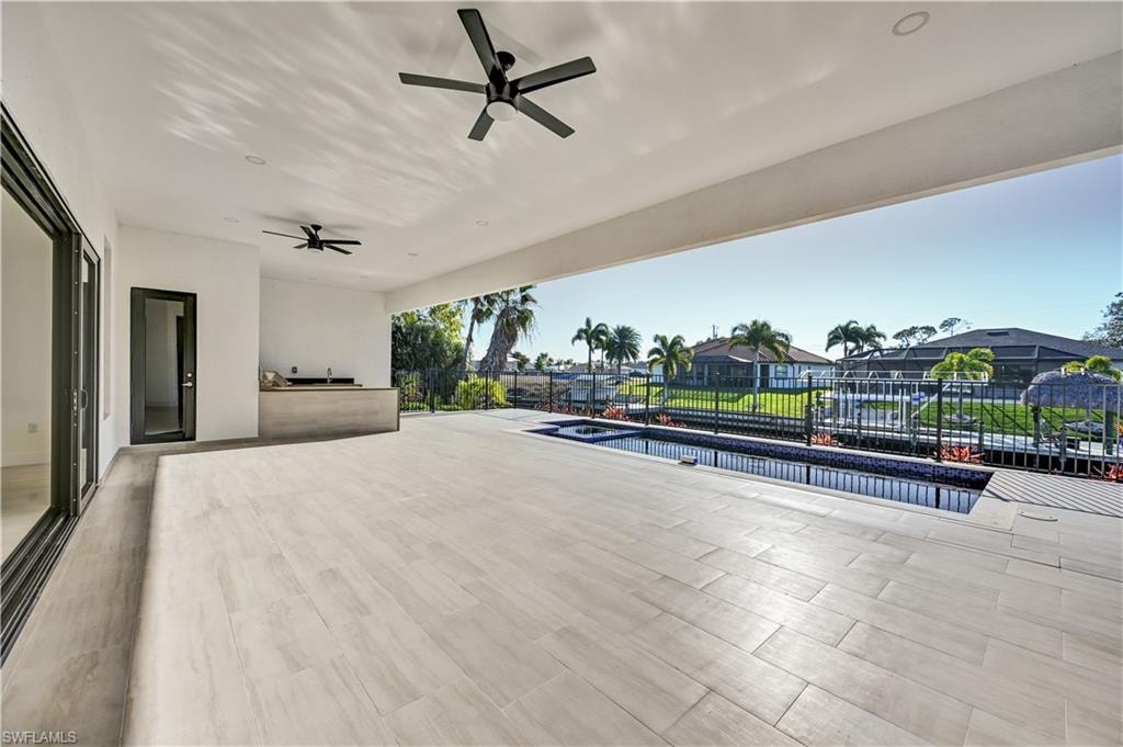 View of patio featuring a ceiling fan and an outdoor pool
